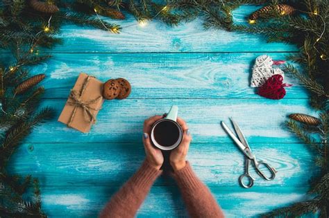 Free Photo Girl Holding A Cup Of Hot Cocoa On A Wooden Blue Background Christmas Concept