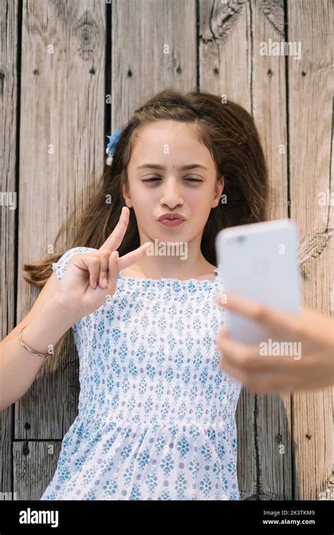 From Above Young Girl Pouting Lips And Gesturing Two Fingers While