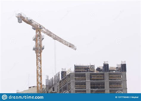 Construction Cranes And High Rise Building Under Construction Against