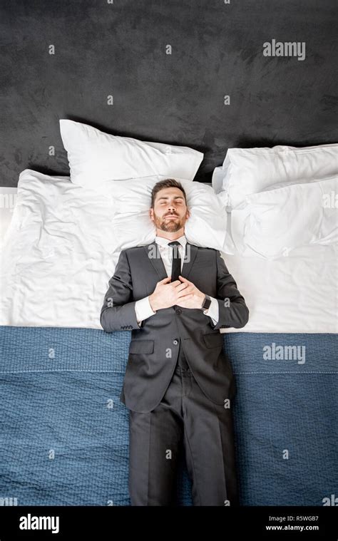 Businessman In The Suit Lying On The Bed Like A Dead Man At The Hotel