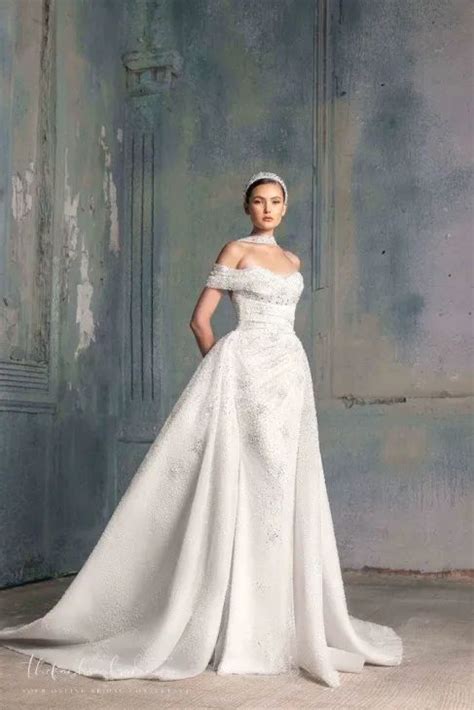 A Woman In A White Wedding Dress Posing For The Camera With Her Hands