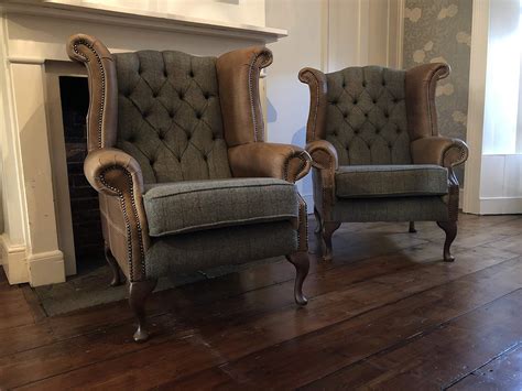 A Pair Of Chesterfield Queen Anne High Back Wing Chairs Presented In