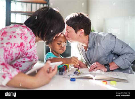 Affectionate Lesbian Couple Kissing Cute Son Painting At Home Stock Photo Alamy