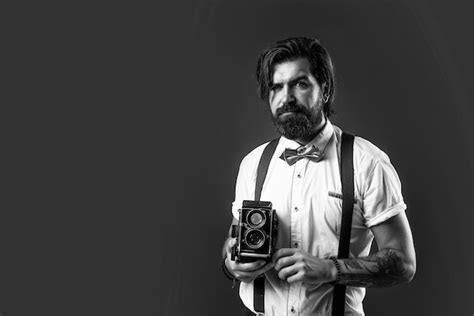 Premium Photo Mature Serious Man In Suspenders Using Retro Camera Over Red Background