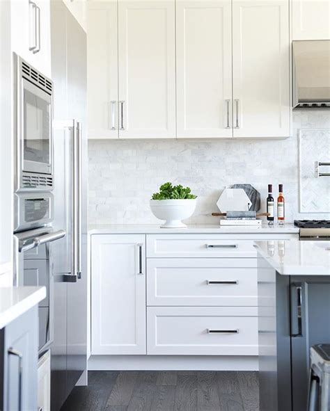 white shaker panel cabinets + dark grey island + marble backsplash | White shaker kitchen ...