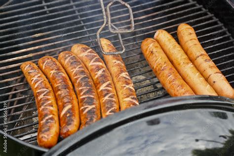 Foto de Würstchen auf Grill mit Grillzange, Glut und Rost do Stock ...