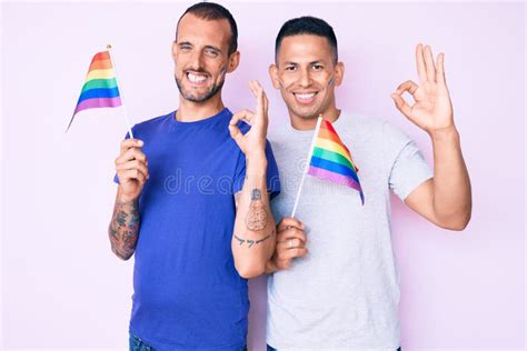 Joven Pareja Gay De Dos Hombres Con Banderas Arcoiris Lgbtq Juntos Haciendo Un Buen Signo Con