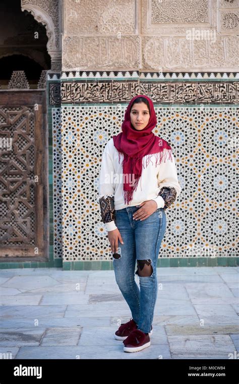 Arab Woman In Modern Clothing With Red Hijab In Front Of The Wall With