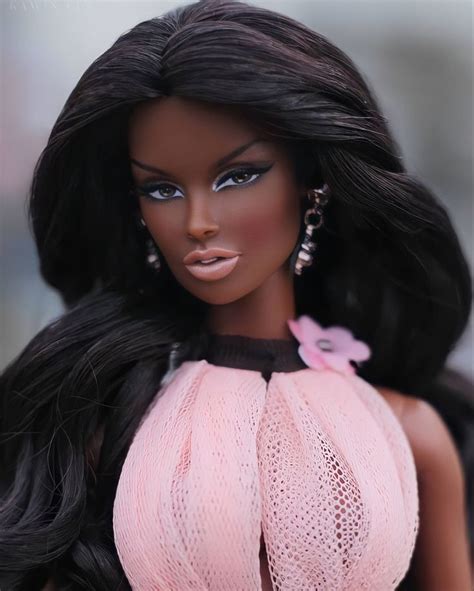 A Close Up Of A Barbie Doll With Long Black Hair Wearing A Pink Dress