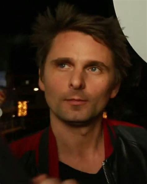 A Close Up Of A Person Wearing A Black Shirt And Red Jacket With His