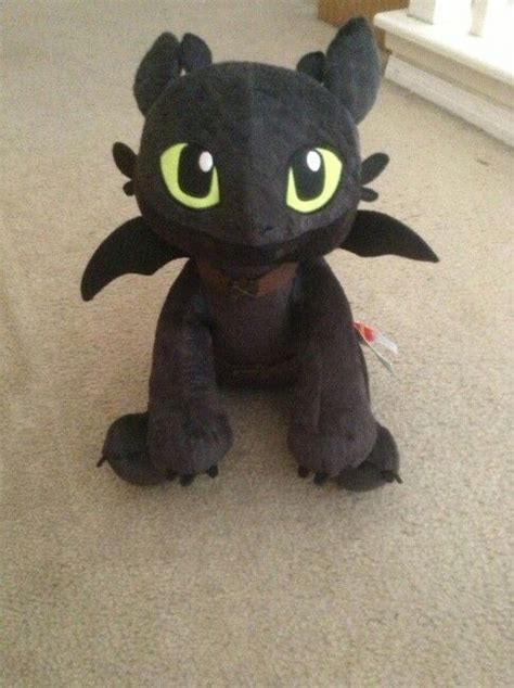 A Black Stuffed Dragon Sitting On The Floor