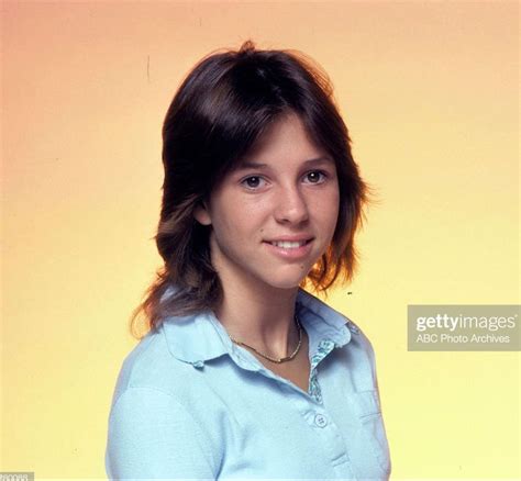 A Young Woman Posing For A Photo In Front Of A Yellow Background