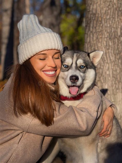 Young Woman Embracing Her Dog A Husky Close Up Vertical Photo Stock