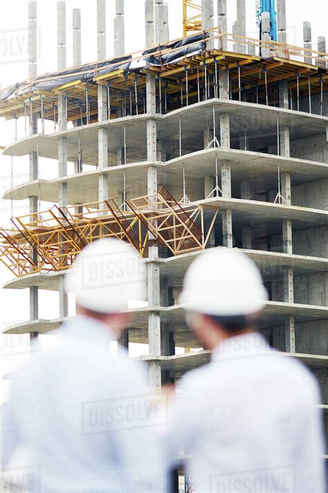 Unfinished structure with two architects near by - Stock Photo - Dissolve