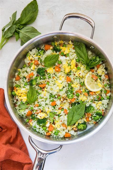 Skillet Of Basil Fried Rice On A White Backdrop With A Red Napkin And