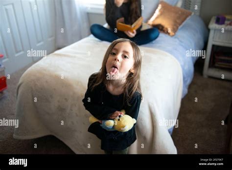 Petite Fille Debout Tirant La Langue Banque De Photographies Et D