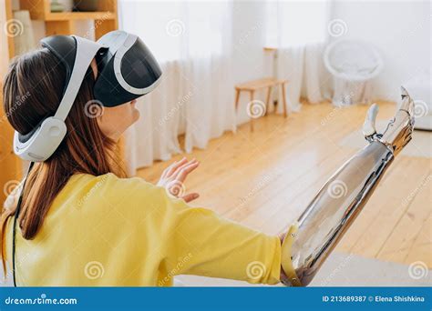 Woman With Bionic Arm And Vr Headset Plays Game In Room Stock Image