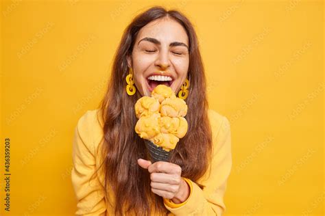 Overjoyed Brunette Woman Eats Tasty Ice Cream On Mango Flavor Bites Appetizing Snack Has Dirty