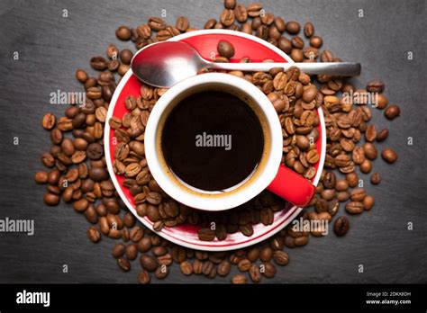 Red Cup Of Coffee With Coffee Beans On Dark Textured Background