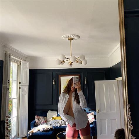 A Woman Taking A Selfie In Front Of A Mirror With Her Reflection On The