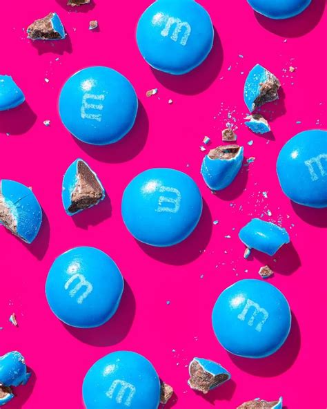 blue m & m candies with the letters m and m in them on a pink background