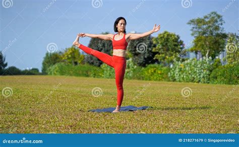 Asian Chinese Female Lady Yogi Practise Yoga Stretches Poses In The Park In Beautiful Weather