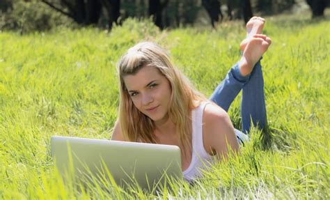 Premium Photo Pretty Blonde Lying On Grass Using Laptop Smiling At Camera