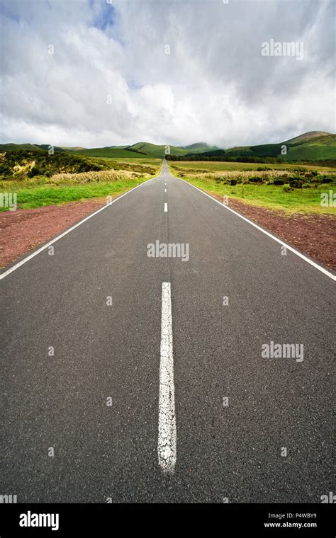 A Dead Straight Road With Road Marking Leads Through A Landscape In