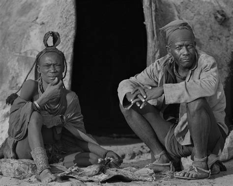 two men sitting on the ground next to each other