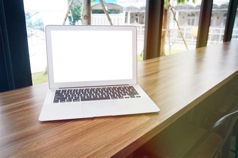 Premium Photo Laptop With Mock Up Blank Screen On Wooden Table In