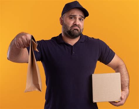 Free Photo Sad Middle Aged Delivery Man In Uniform And Cap Holding