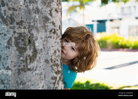 Kids active games. Playing hide and seek. Peekaboo. Little boy hiding ...