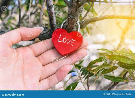 Female Hand Holds A Metal Lock With The Inscription Love In Incense