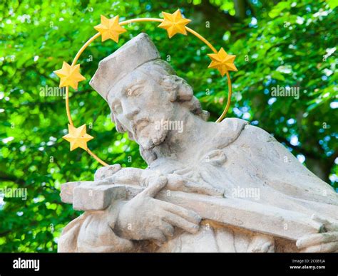 Detailed View Of Statue Of Saint With Golden Halo And Green Trees On