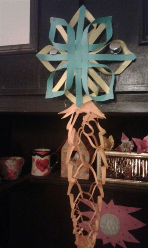 A Paper Snowflake Hanging From The Side Of A Fireplace With Other