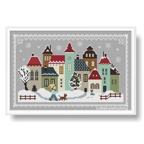 A Cross Stitch Christmas Card With Houses And Trees