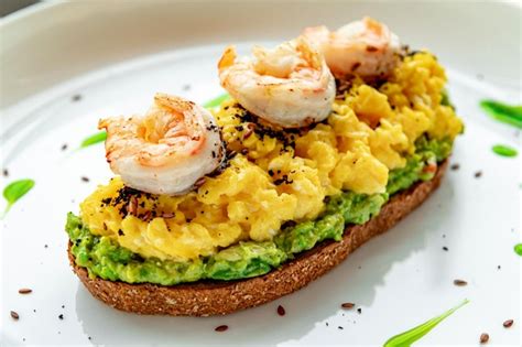 Revuelto Sobre Tostadas Con Guacamole De Gambas Y Aceitunas Foto Premium