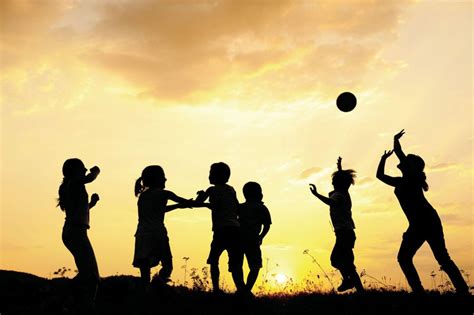 Silhouette, group of happy children playing on meadow, sunset, s ...