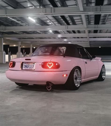 Pink Miata Sports Car With Hood Up And Tail Lights On