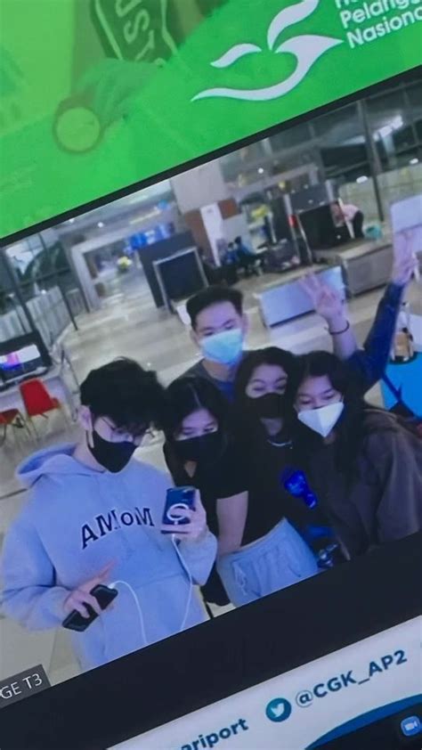 A Group Of People Wearing Face Masks And Holding Cell Phones In Front