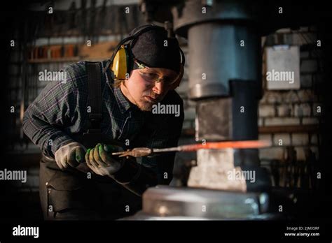 Forging A Detail Out Of The Hot Red Metal Using A Blacksmith Machine Stock Photo Alamy
