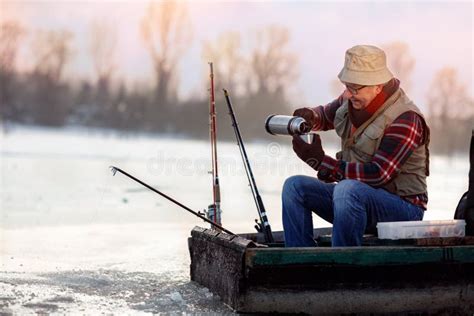 Pesca Do Inverno Pescador Que Senta Se No Ch Congelado Do Lago E Da