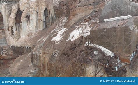 Close Up Of Small Waterfall Over The Brown Cliff Layers Covered With