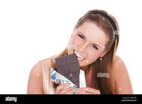 Young Girl Biting A Bar Of Dark Chocolate On Isolated White Stock Photo