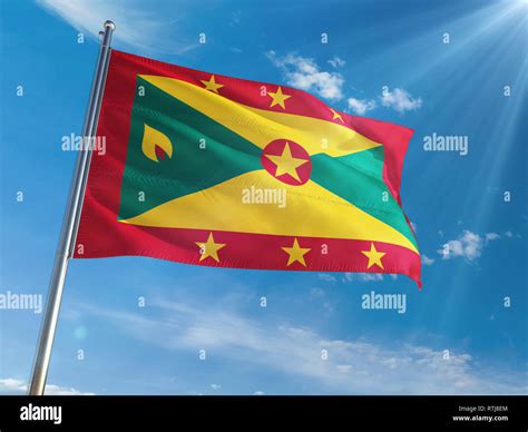 Grenada National Flag Waving On Pole Against Sunny Blue Sky Background High Definition Stock