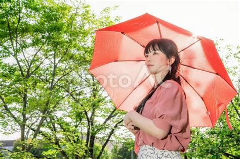 強い日差しの中で赤い日傘をさす女性 No 23972755｜写真素材なら「写真ac」無料（フリー）ダウンロードok