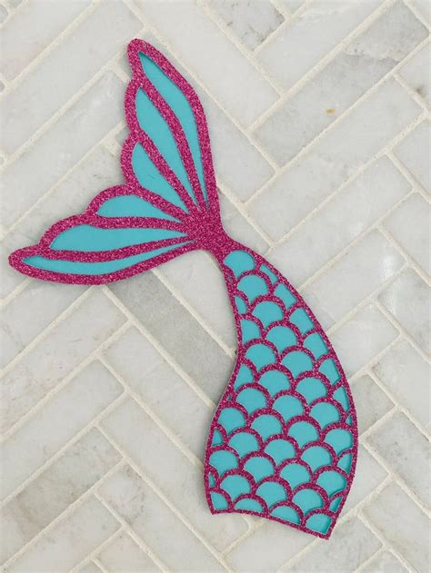 A Blue And Pink Mermaid Tail Shaped Object On A White Tile Floor Next