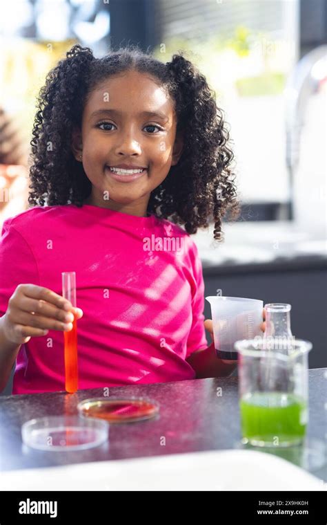 A Biracial Girl With Curly Hair Is Conducting A Science Experiment In