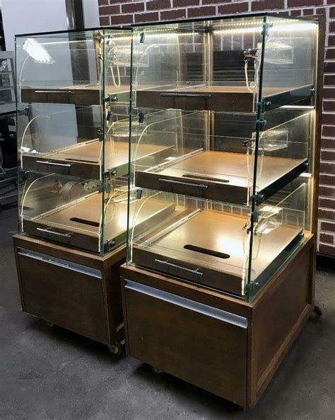 an old fashioned display case with glass shelves and drawers on wheels ...