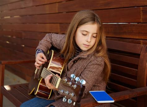 Fille Blonde D Enfant Apprenant La Guitare De Jeu Avec Le Smartphone Photo Stock Image Du